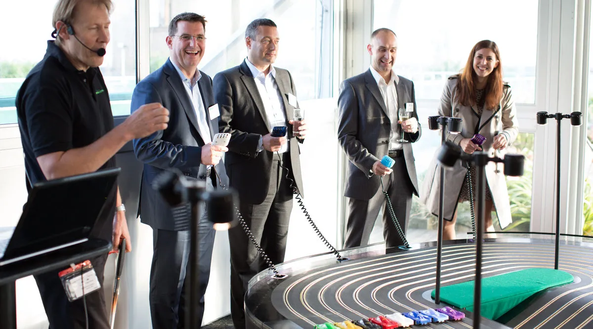 corporate party ideas fun entertainment hire the best events company in the uk miniracing.com Giant Scalextric 8 lane track for hire being played at an exhibition event slot racing hire